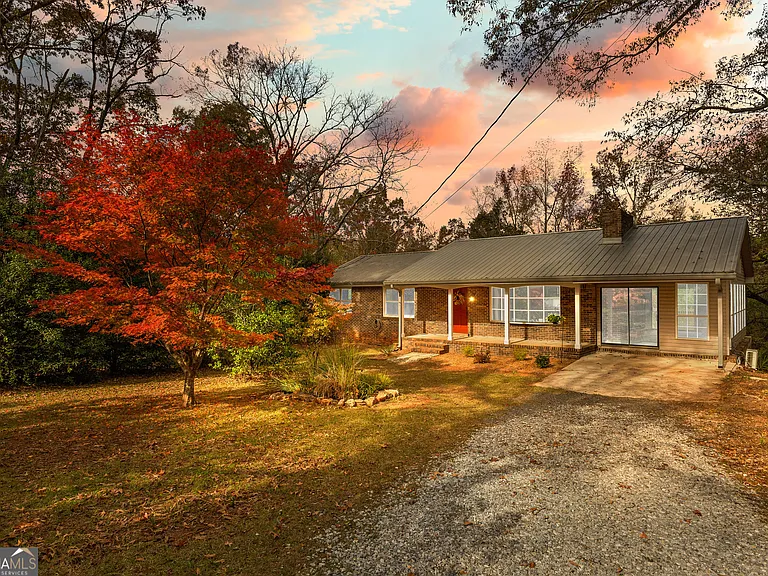 A house with trees and bushes in the background.
